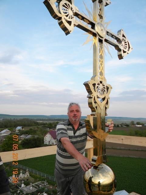 Aşezând noua cruce din titan aurit pe turla bisericii
